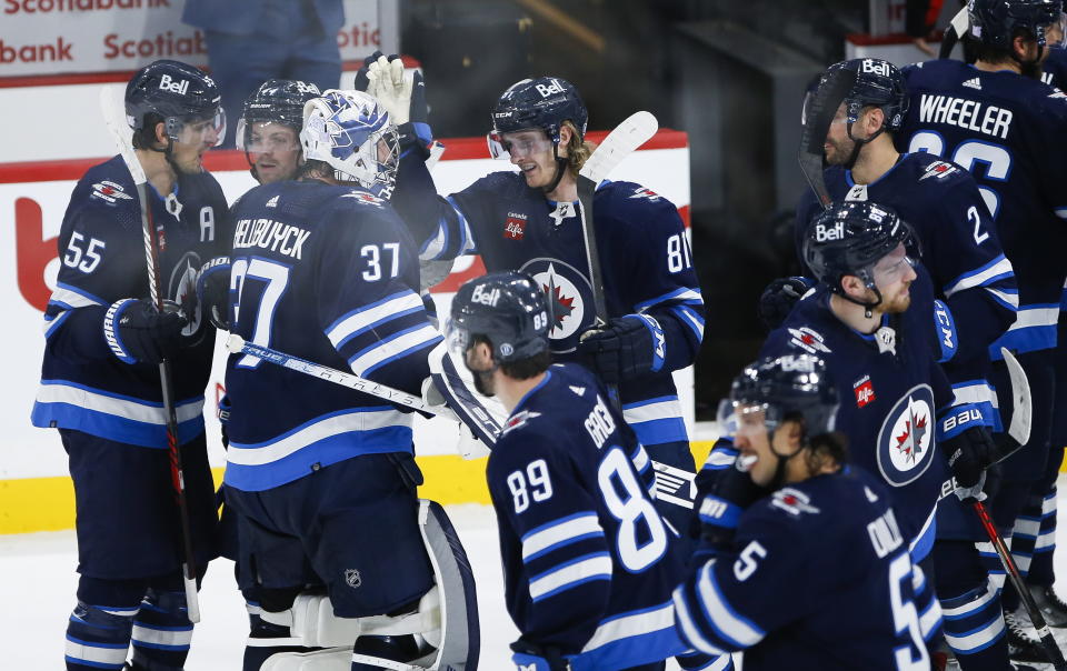 Winnipeg Jets' Kyle Connor (81) and goaltender Connor Hellebuyck (37) celebrate the team's overtime win against the Montreal Canadiens in an NHL hockey game Thursday, Nov. 3, 2022, in Winnipeg, Manitoba. (John Woods/The Canadian Press via AP)