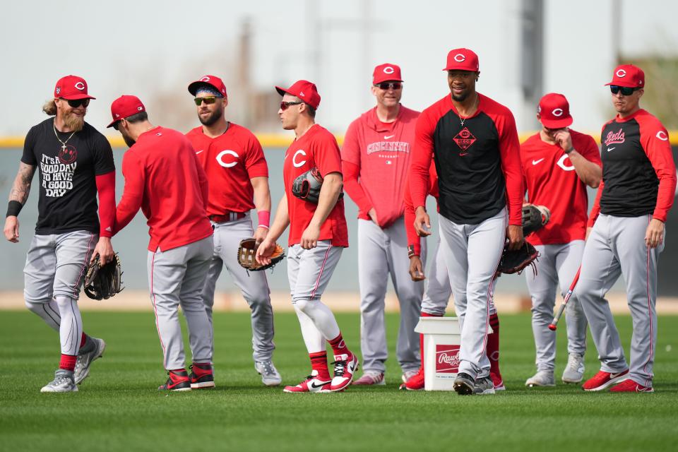 Cincinnati Reds outfielder Jake Fraley, first base coach Collin Cowgill, right fielder Nick Martini (23), center fielder TJ Friedl (29) and outfielder Will Benson, third from right, walk back at the conclusion of outfield drills during spring training workouts, Friday, Feb. 23, 2024, at the team’s spring training facility in Goodyear, Ariz.