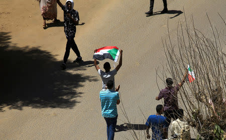 Sudanese demonstrators wave the national flag as they chant slogans during a protest demanding Sudanese President Omar Al-Bashir to step down in Khartoum, Sudan April 6, 2019. REUTERS/Stringer