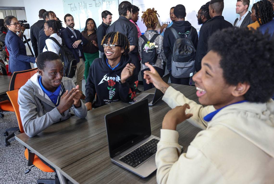 Seniors at the Academy of Information Technology, Winston Wright, 17, left, Anthony Alphonse Alvarez, 17, and Kaleb Isiah Clarke, 17, right, react to the acknowledgment of a Black tech innovation center for college students and community members in Miami Gardens at Florida Memorial University on Thursday, Jan. 26, 2023.