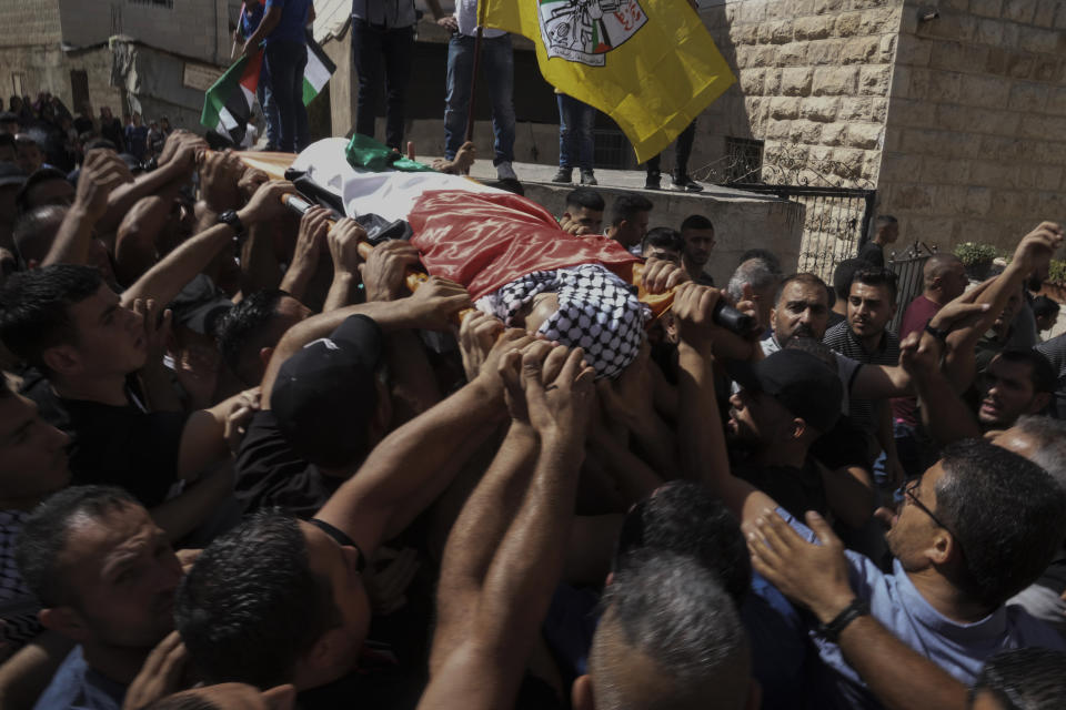 Mourners carry the body of 7-year-old Palestinian boy Rayan Suleiman during his funeral in the West Bank village of Tequa near Bethlehem Friday, Sept. 30, 2022. The U.S. State Department has called on Israel to open a "thorough" investigation into the mysterious death of the boy, who collapsed and died shortly after Israeli soldiers came to his home in the occupied West Bank. Relatives said he had no previous health problems and accused the army of scaring the child to death. The army called the death a tragedy and said its soldiers were not to blame. (AP Photo/Mahmoud Illean)