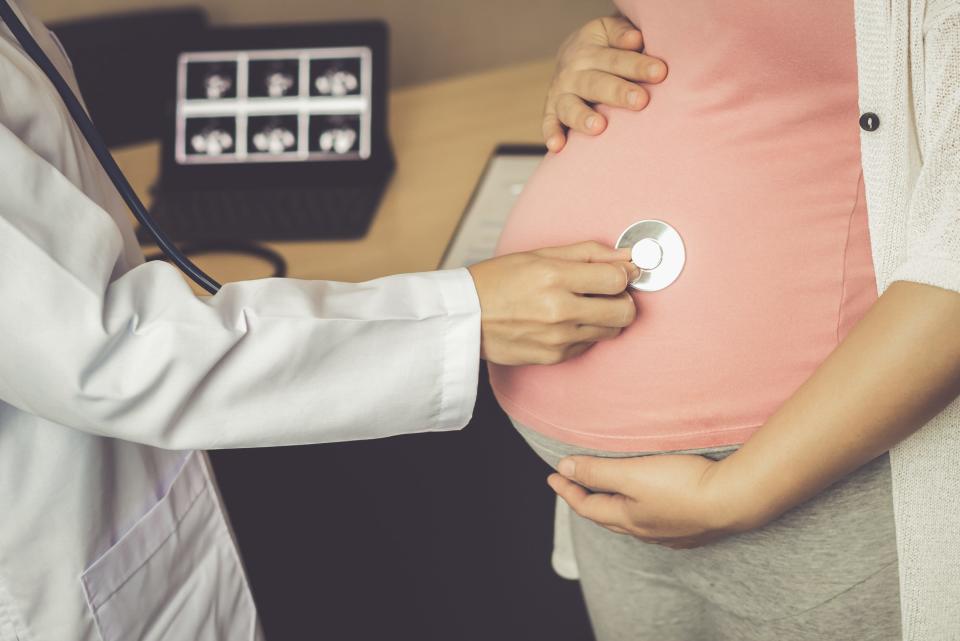 A pregnant woman is examined by a doctor as part of a routine health care checkup.