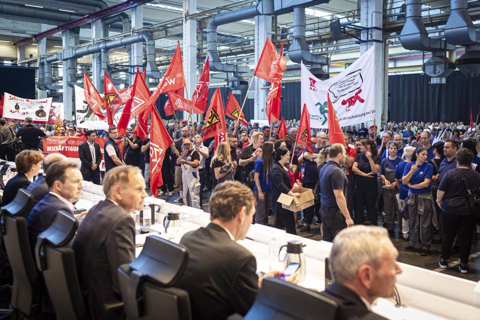 Employees protest before the start of a works meeting in a hall at the VW plant in Wolfsburg, Wednesday, Sept. 4, 2024. Volkswagen has announced that it will tighten its austerity measures due to the tense situation of the core brand. Redundancies and plant closures can no longer be ruled out. (Moritz Frankenberg/pool photo via AP)