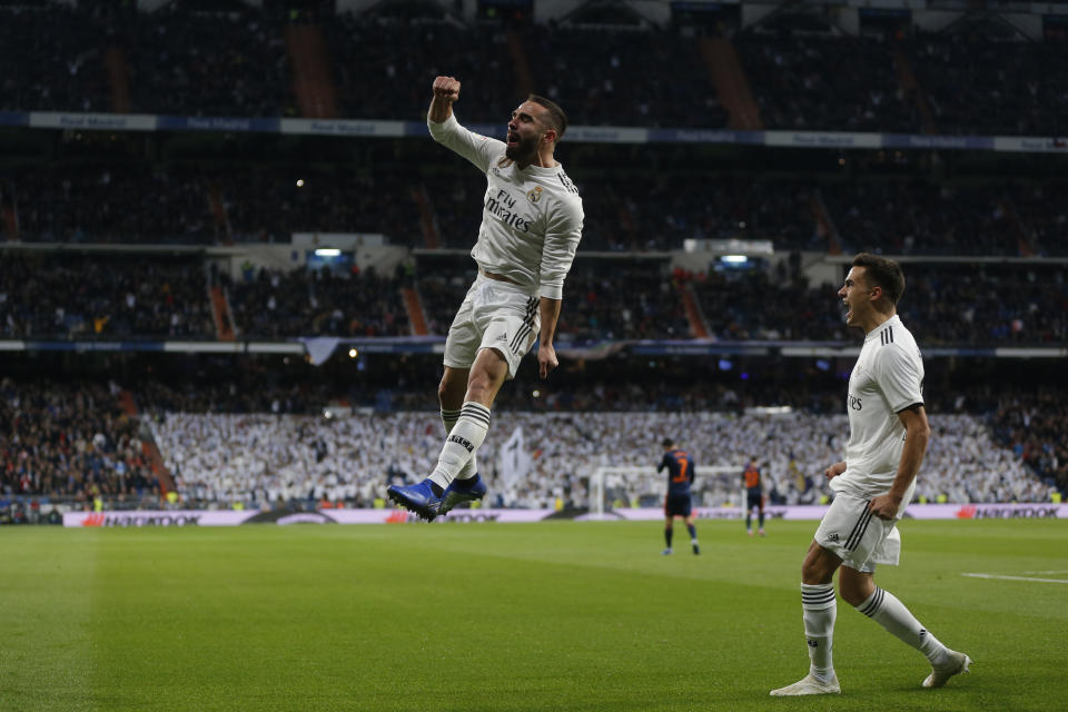 Real Madrid's Dani Carvajal, left, celebrates after Valencia's Daniel Wass scored an own goal during a Spanish La Liga soccer match between Real Madrid and Valencia at the Santiago Bernabeu stadium in Madrid, Spain, Saturday, Dec. 1, 2018. (AP Photo/Paul White)