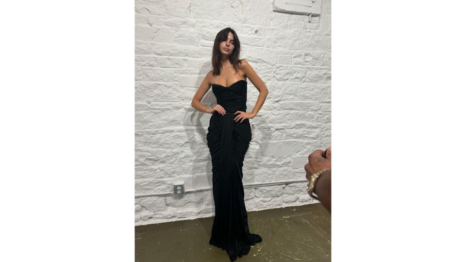 Emily Ratajkowski poses in a black gown during NYFW