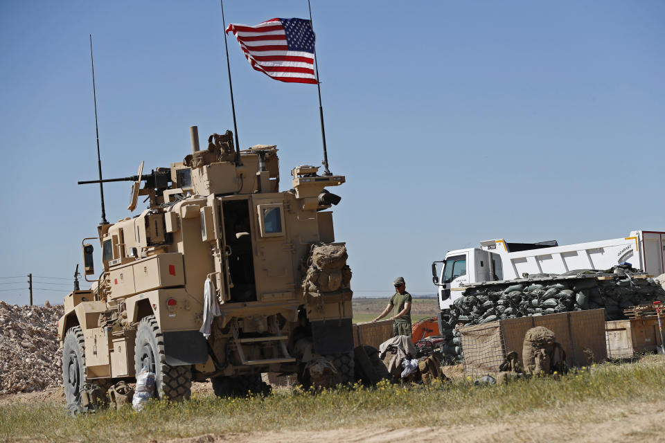 FILE -- In this April 4, 2018 file photo, a U.S. soldier stands in a newly installed position near the front line between the U.S-backed Syrian Manbij Military Council and the Turkish-backed fighters, in Manbij, north Syria. The planned U.S. troop withdrawal opens a void in the north and east of Syria, and the conflicts and rivalries among all the powers in the Middle East are converging to fill it. (AP Photo/Hussein Malla, File)