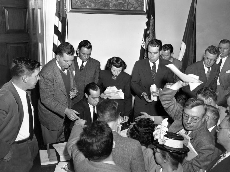 Richard Nixon (center) speaks to reporters