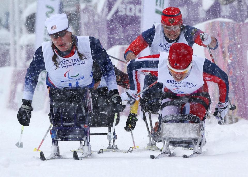 Mariann Marthinsen of Norway, right, 1st place, Tatyana Mcfadden of United States, left, 2nd place, and Marta Zaynullina of Russia, rear right, 3rd place, finish in final of the women's cross country 1km sprint, sitting event at the 2014 Winter Paralympic, Wednesday, March 12, 2014, in Krasnaya Polyana, Russia. (AP Photo/Dmitry Lovetsky)