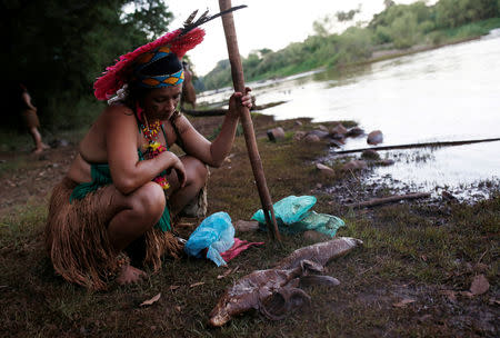 An Indigenous woman from the Pataxo Ha-ha-hae tribe looks at dead fish near Paraopeba river, after a tailings dam owned by Brazilian mining company Vale SA collapsed, in Sao Joaquim de Bicas near Brumadinho, Brazil January 28, 2019. REUTERS/Adriano Machado