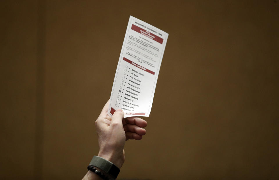 A man holds up a preference card with Democratic presidential candidate Sen. Bernie Sanders, I-Vt., marked, during a presidential caucus at the Bellagio hotel-casino, Saturday, Feb. 22, 2020, in Las Vegas. (AP Photo/John Locher)