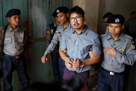 Detained Reuters journalist Wa Lone is escorted by police before a court hearing in Yangon, Myanmar May 21, 2018. REUTERS/Ann Wang