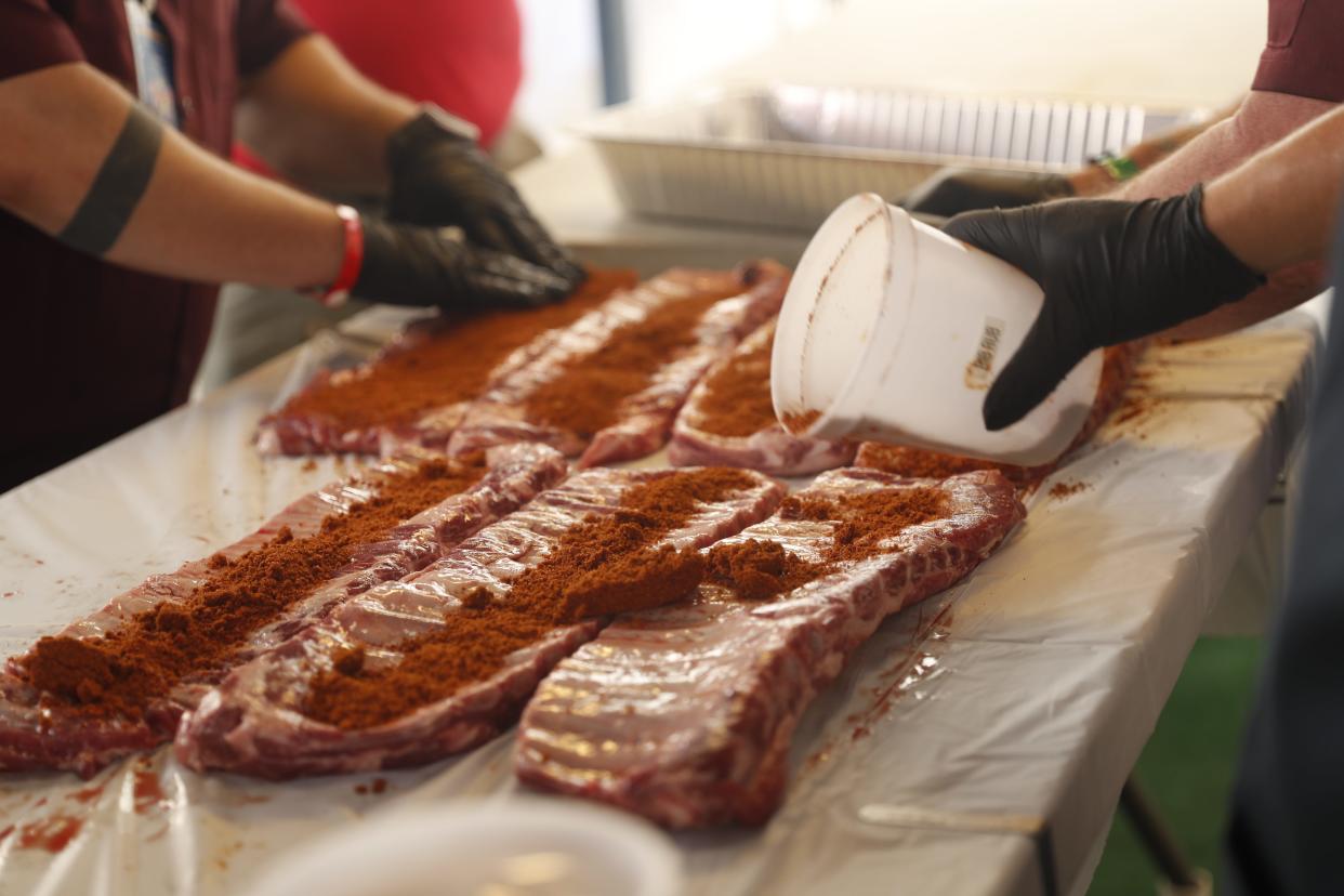 Swine & Dine members prepare and season their ribs on May 19, 2023, during the Memphis in May World Championship Barbecue Cooking Contest at Tom Lee Park in Downtown Memphis.