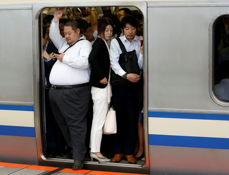 FILE PHOTO: Passengers ride a crowded train at a station in Kawasaki, Japan