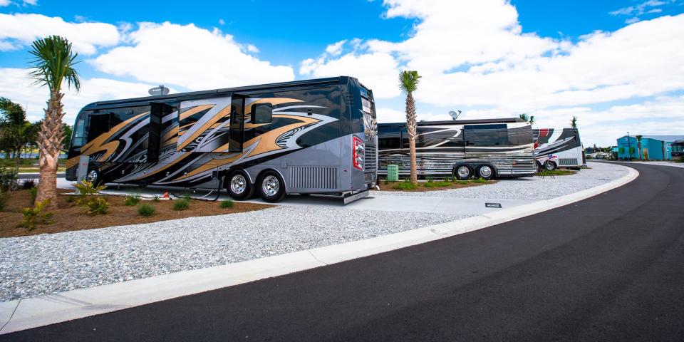 Parked Class A RVs in a row at the camp.