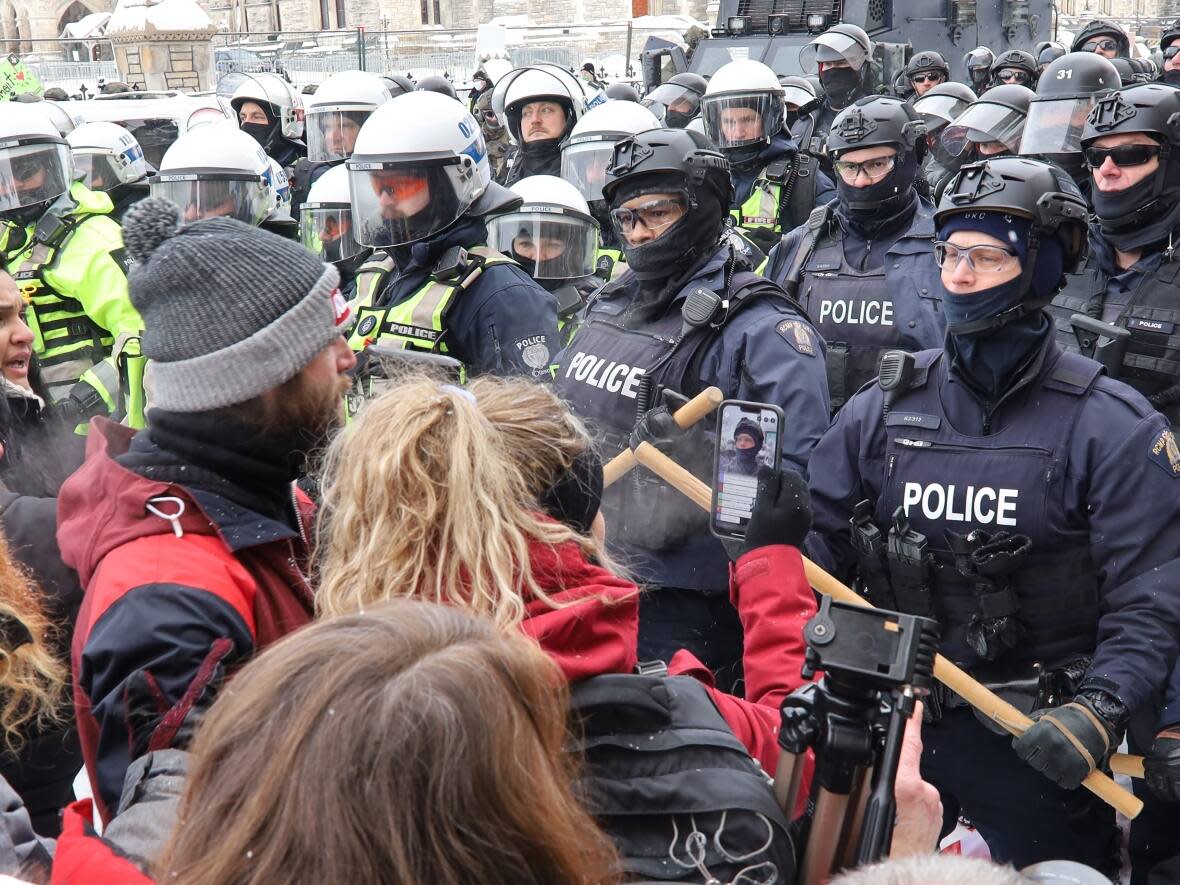 Police advance against protesters on Wellington Street in Ottawa, during the weeks-long convoy protests, in February 2022. (Michael Charles Cole/CBC - image credit)