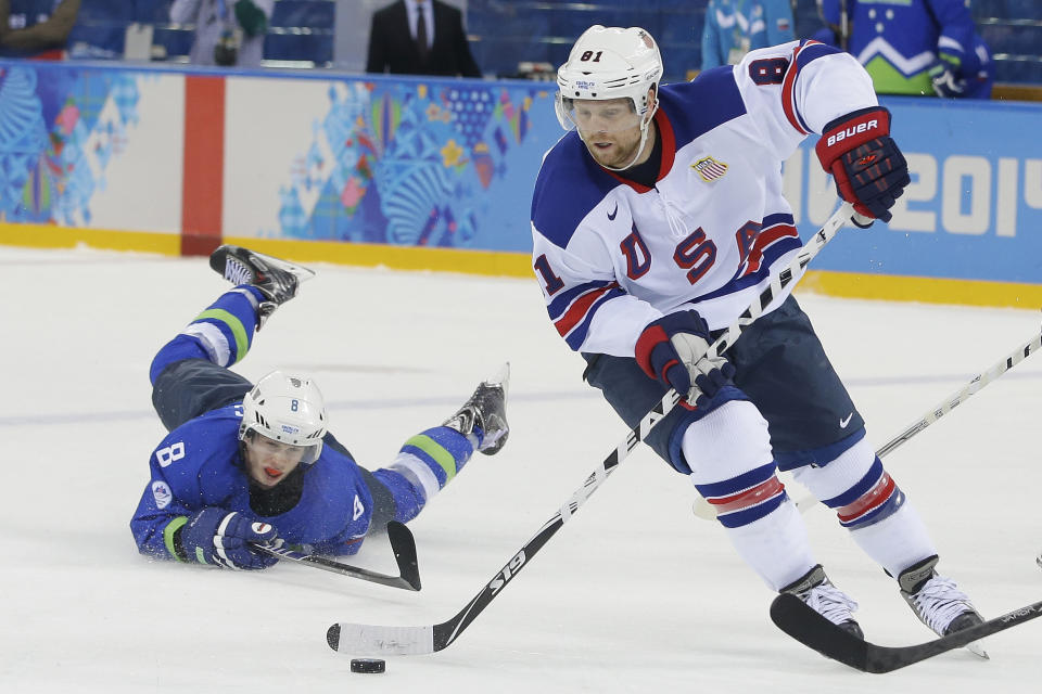 USA forward Phil Kessel take the puck away from Slovenia forward Ziga Jeglic during the 2014 Winter Olympics men's ice hockey game at Shayba Arena Sunday, Feb. 16, 2014, in Sochi, Russia. (AP Photo/Matt Slocum)