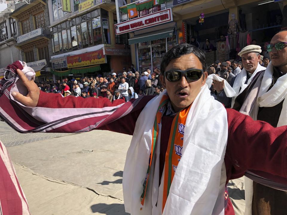 A man wearing a scarf with Bharatiya Janata Party's symbol dances as people celebrate change of status of Ladakh region to a Union Territory in Leh, India, Thursday, Oct. 31, 2019. India on Thursday formally implemented legislation approved by Parliament in early August that removes Indian-controlled Kashmir's semi-autonomous status and begins direct federal rule of the disputed area amid a harsh security lockdown and widespread public disenchantment. The legislation divides the former state of Jammu-Kashmir into two federally governed territories, Jammu and Kashmir and Ladakh. (AP Photo/Sheikh Saaliq)