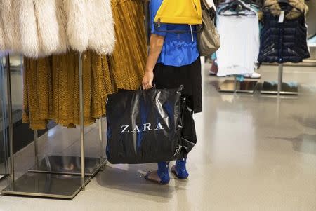 A woman holds a bag inside a Zara store in Madrid September 12, 2014. REUTERS/Andrea Comas