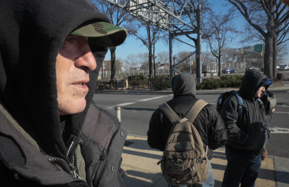 Mario Bonilla, 54, left, a day laborer from Ecuador, wait with other day laborers at a highway intersection, hoping to get work from contractors who stop and hire on the spot, on Wednesday, Dec. 11, 2013 in the Queens, N.Y. Bonilla, 54, from Ecuador, has been looking for jobs in Queens street corners for at least two decades and says his life is harder now. (AP Photo/Bebeto Matthews)