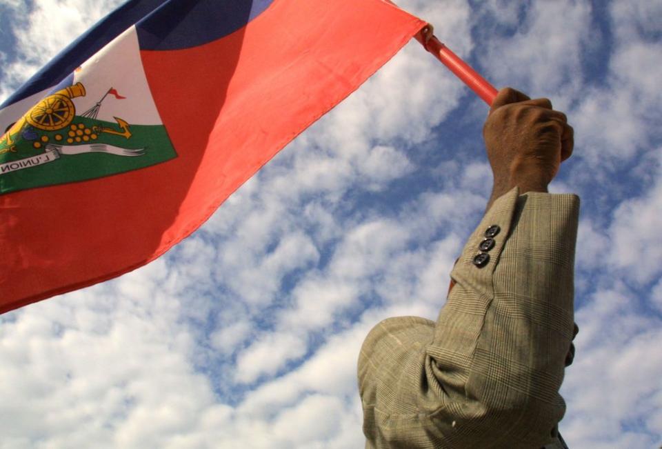 A man holds a Haitian flag