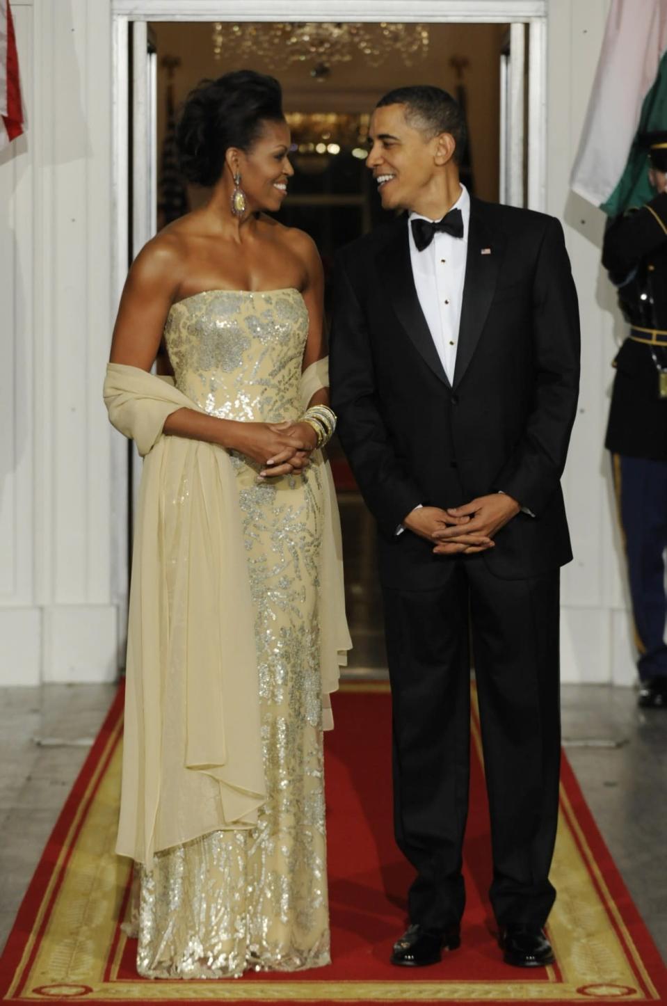 For Michelle Obama’s first state dinner in November 2009 hosting India’s Prime Minister Manmohan Singh and his wife Gursharan Kaur, she wore a dress from go-to designer Naeem Khan featuring glitter florals. (Photo: Getty Images)