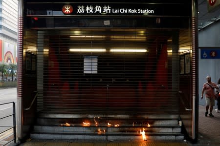 Petrol bombs burn at the entrance to the MTR station after a protest against the invocation of the emergency laws in Hong Kong