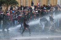 Demonstrators are hit by water canon during a protest against a ruling elite accused of steering Lebanon towards economic crisis in Beirut