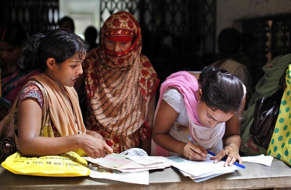 In this Wednesday, Aug. 29, 2012 photo, Unemployed educated Indian women fill forms to register themselves at the Employment Exchange Office in Allahabad, India. India, with the world's largest chunk of illiterates at over 250 million, has to invest heavily in education and skills training, said Ashish Bose, a leading demographer. While millions of job seekers have impressive sounding diplomas, many don't have the skills promised by those certificates from colleges and technical institutes with poor standards. (AP Photo/Rajesh Kumar Singh)