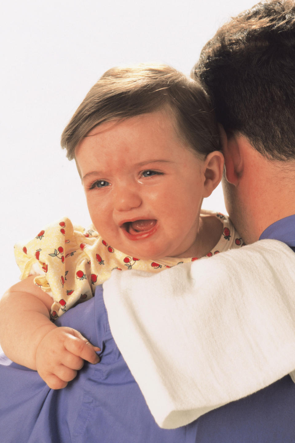 baby crying on dad's shoulder