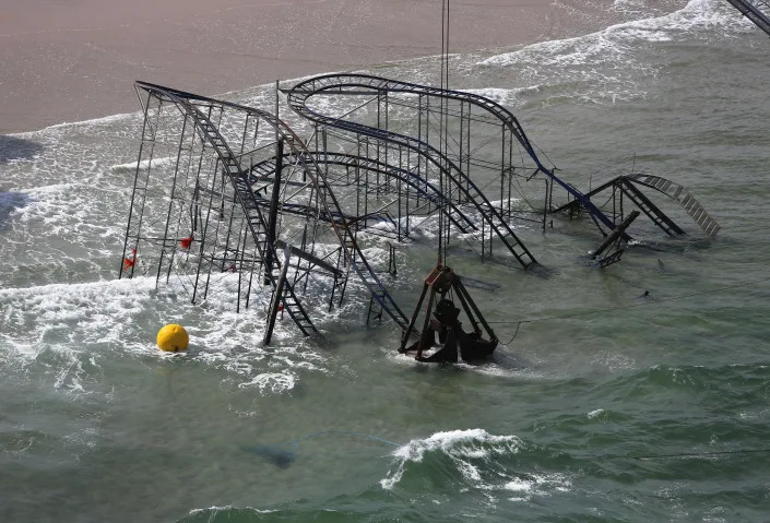 SEASIDE HEIGHTS, NJ - MAY 14: A crane demolishes the JetStar roller coaster more than 6 months after it fell into the ocean during Superstorm Sandy on May 14, 2013 in Seaside Heights, New Jersey. The Casino Pier contracted Weeks Marine to remove the wreckage of the iconic roller coaster from the surf. (Photo by John Moore/Getty Images)