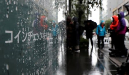 FILE PHOTO: Journalists are seen next to Cryptocurrency exchange Coincheck's signboard while Japan's financial regulator conducts a spot inspection on Coincheck, in Tokyo, Japan February 2, 2018. REUTERS/Kim Kyung-Hoon/File Photo