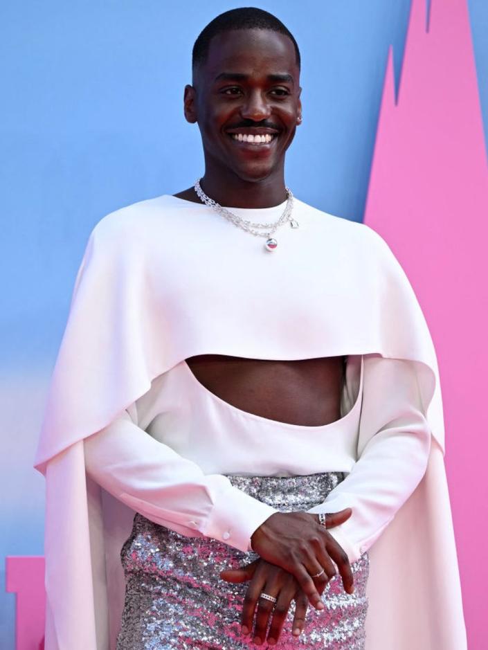 Ncuti Gatwa poses in a cut-out white top and sequinned shorts.