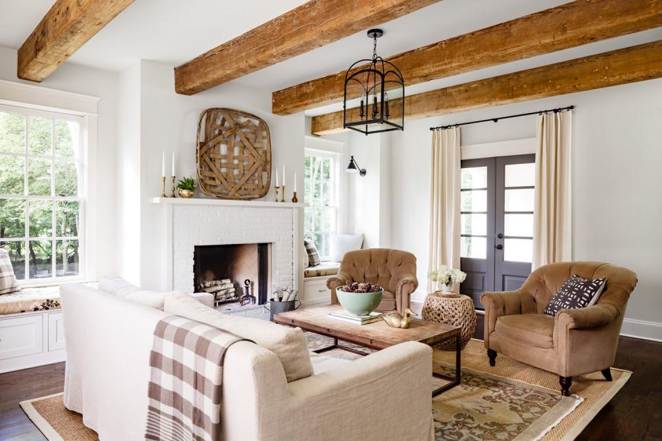 farmhouse living room with neutral furniture and exposed beams