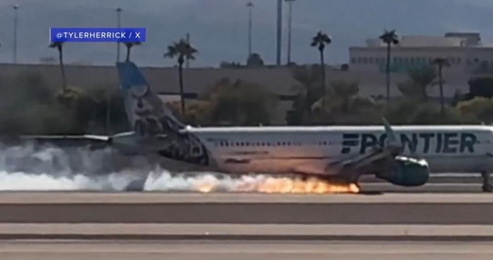 Flames and smoke were seen coming from a plane that made a hard landing at Harry Reid International Airport in Las Vegas on Saturday afternoon. (Courtesy of @Tylerherrick)