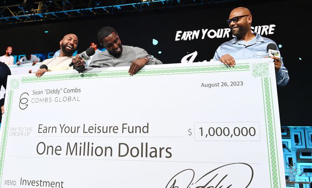 <p>Paras Griffin/Getty</p> Sean "Diddy" Combs presents the Earn Your Leisure Fund with a $1 million check at Invest Fest in Atlanta.