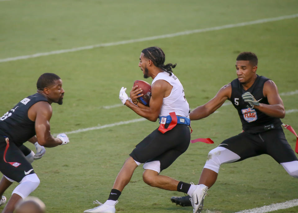 Stevland Morris, Michael Johnson and Terrell Hayden run during a flag football game