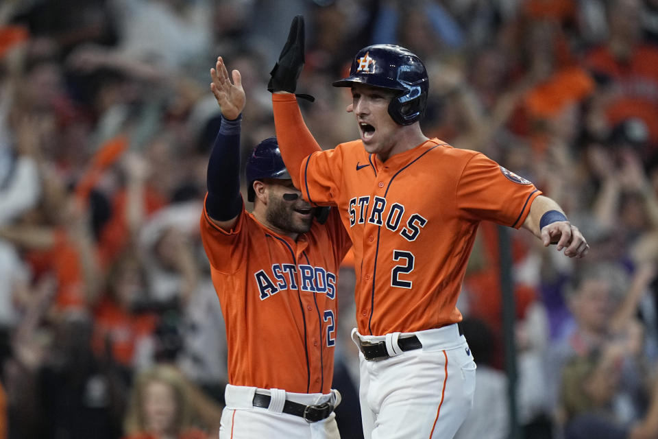 Houston Astros' Alex Bregman (2) and Jose Altuve (27) celebrate as they score on teammate Yuli Gurriel's single during the fifth inning in Game 2 of a baseball American League Division Series against the Chicago White Sox,Friday, Oct. 8, 2021, in Houston. (AP Photo/David J. Phillip)