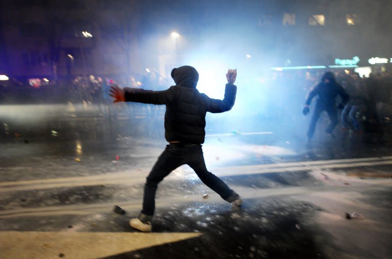 A demonstrator throws a rock to riot police during clashes on the sidelines of a protest against the government in downtown Sofia on February 19, 2013. Bulgaria's prime minister announced Wednesday the surprise resignation of his government after days of sometimes violent rallies, paving the way for early elections in the European Union's poorest member