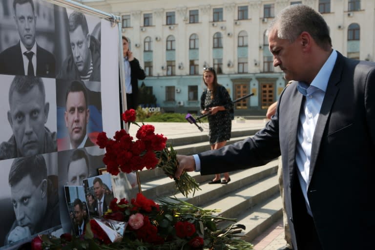 Crimean leader Sergei Aksyonov lays flowers at the improvised memorial to Alexander Zakharchenko, the 42-year-old head of the self-proclaimed Donetsk People's Republic, who was killed in a bombing in the rebel-controlled city of Donetsk on Friday