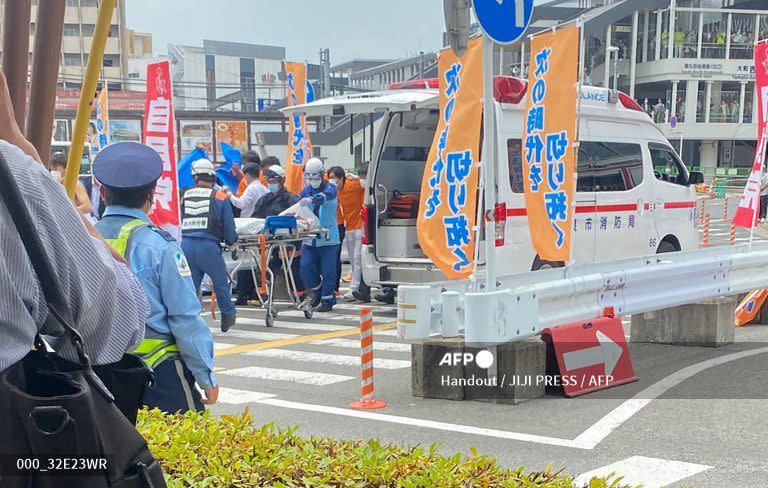 Los médicos trasladar al dirigente japonés, después del ataque. AFP PHOTO / JIJI PRESS.