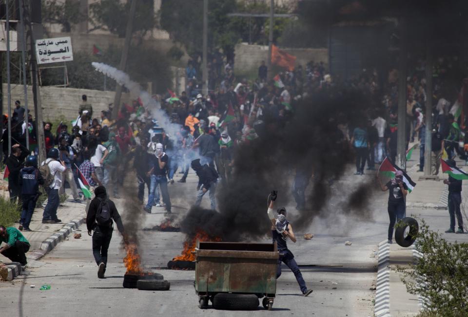 Palestinians throw stones at Israeli troops during a protest calling for the release of Palestinian prisoners held in Israeli jails, outside Ofer, an Israeli military prison near the West Bank city of Ramallah, Friday, April 4, 2014. (AP Photo/Majdi Mohammed)