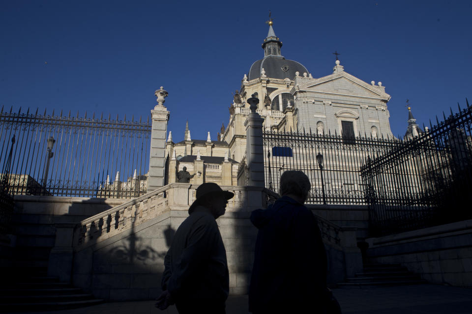 A tourist walks in front of the Almudena cathedral in Madrid, Spain, Thursday, Oct. 25, 2018. Hundreds of protesters in Madrid are urging government and Catholic church authorities to prevent the remains of the country’s 20th century dictator from ending in the city’s cathedral. Spain’s center-left government has promised to exhume this year Gen. Francisco Franco from a glorifying mausoleum, but the late dictator’s heirs have defied the plans by proposing for his remains to be relocated to a family crypt under the cathedral. (AP Photo/Paul White)