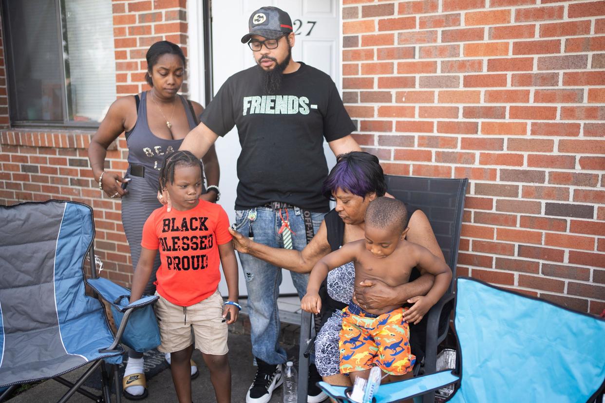 The family of 21-year-old Ta'Kiya Young, sit out side their home including her grandmother, Nadine Young, 61, right and her two boys, Ja'Kobie Young, 6, left and Ja'Kenli Young, 3. Ta'Kiya was pregnant with a girl and due in November, according to family.