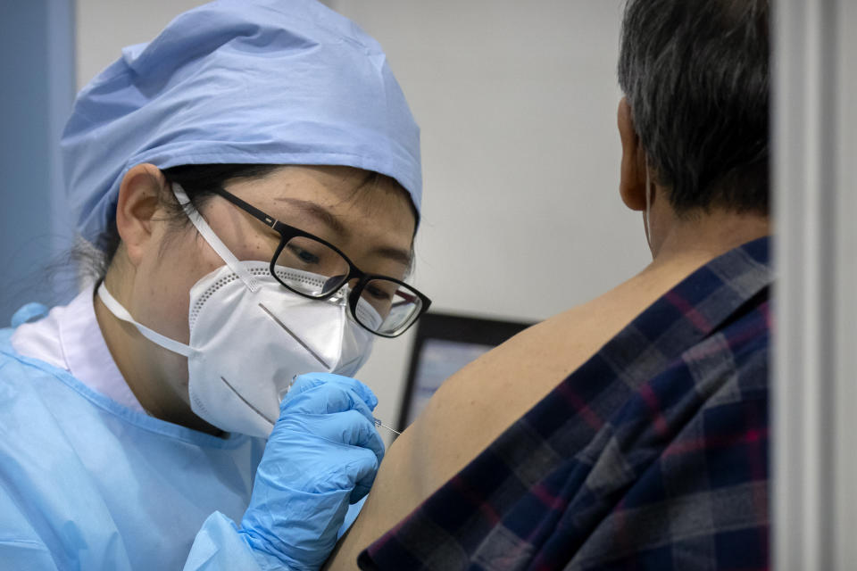 FILE - A medical worker gives a coronavirus vaccine shot to a patient at a vaccination facility in Beijing on Jan. 15, 2021. The Chinese capital has issued a mandate requiring people to show proof of COVID-19 vaccination before they can enter some public spaces including gyms, museums and libraries, with exceptions only available to those who cannot be vaccinated for health reasons. (AP Photo/Mark Schiefelbein, File)
