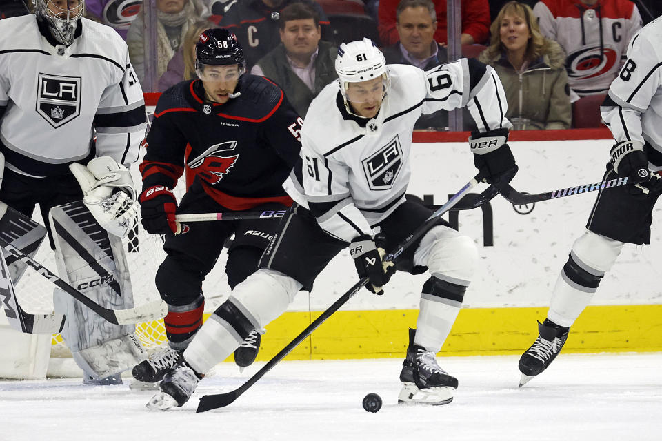 Los Angeles Kings' Trevor Lewis (61) protects the puck from Carolina Hurricanes' Michael Bunting (58) during the first period of an NHL hockey game in Raleigh, N.C., Monday, Jan. 15, 2024. (AP Photo/Karl B DeBlaker)