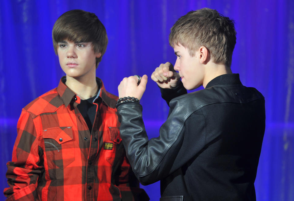 Canadian singer Justin Bieber (black top) poses with a waxwork model of himself during an official unveiling at Madame Tussauds Wax Museum in central London March 15, 2011. REUTERS/Toby Melville