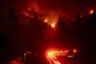 <p>Fire trucks pass the Delta Fire burning in the Shasta-Trinity National Forest, Calif., on Wednesday, September 5, 2018. Parked trucks lined more than two miles of Interstate 5 as both directions remained closed to traffic. (AP Photo/Noah Berger) </p>