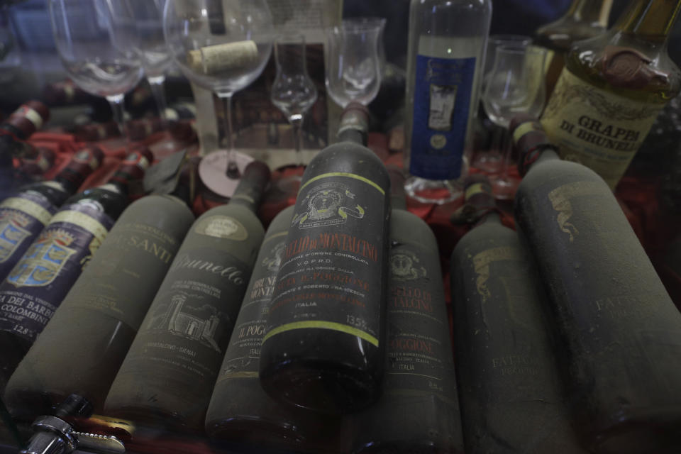 Bottles of Brunello wine are displayed at a bar in Montalcino, Italy, Friday, May 28, 2021. It is a long way, and a risky one. But for this group of migrants at least it was worth the effort. They come from Ghana, Togo, Sierra Leone, Pakistan, Guinea Bissau, among other countries. They all crossed the Sahara desert, then from Libya the perilous Mediterranean Sea until they reached Italian shores, now they find hope working in the vineyards of Tuscany to make the renown Brunello wine. (AP Photo/Gregorio Borgia)