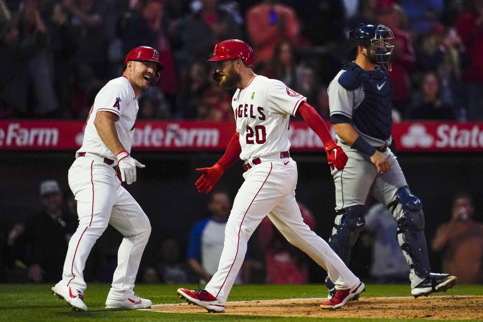 CORRECTS TO FOURTH INNING NOT THIRD INNING - Los Angeles Angels' Jared Walsh (20) celebrates with Mike Trout, left, after hitting a home run during the fourth inning of a baseball game against the Tampa Bay Rays in Anaheim, Calif., Monday, May 9, 2022. Mike Trout and Shohei Ohtani also scored. (AP Photo/Ashley Landis)