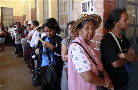 People line up before voting at a polling centre in the capital Antananarivo, October 25, 2013. REUTERS/Thomas Mukoya